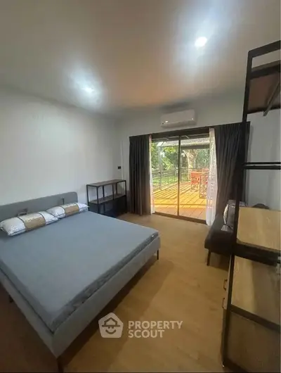 Spacious bedroom with balcony access and modern furnishings