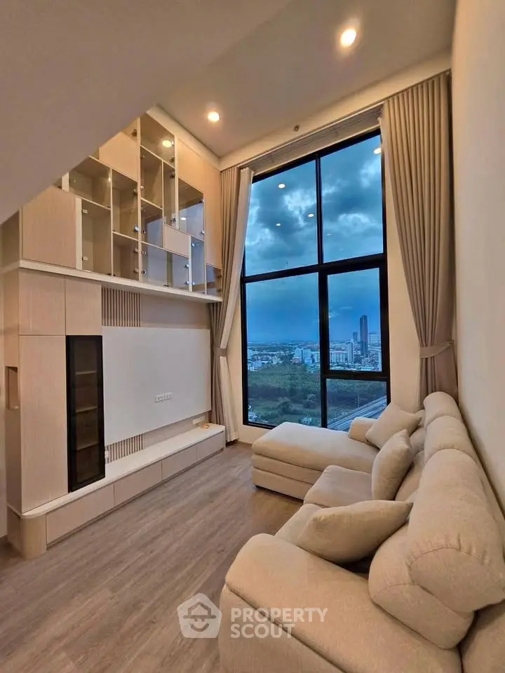 Luxurious living room with floor-to-ceiling windows and stunning city view.