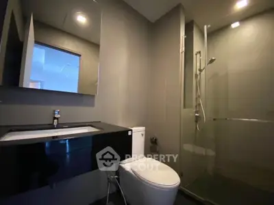 Modern bathroom with sleek design featuring glass shower and stylish vanity.