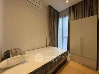 Cozy bedroom with modern furnishings and natural light in a stylish apartment.