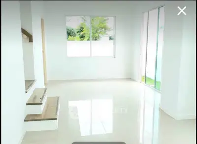 Bright and airy living room with large windows and modern staircase