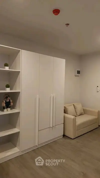 Modern living room with sleek white furniture and cozy sofa, perfect for urban living.