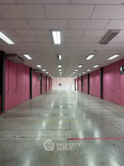 Spacious industrial warehouse with high ceilings and ample lighting, ideal for storage or manufacturing.