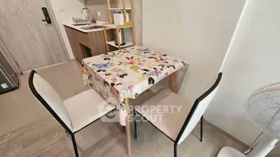 Cozy dining area with floral tablecloth and modern kitchen setup
