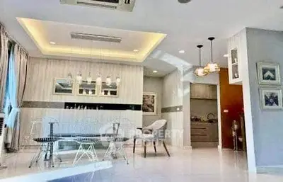 Spacious modern living room with elegant dining area and stylish lighting fixtures.