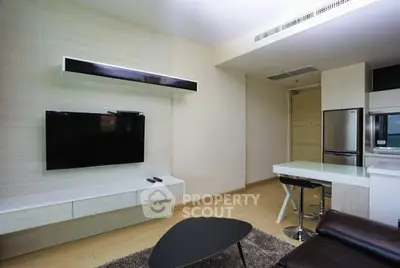 Modern living room with sleek TV setup and stylish furniture in a contemporary apartment.