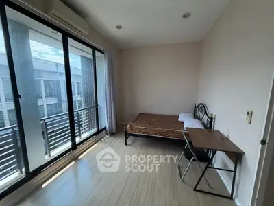 Spacious bedroom with balcony access and natural light in modern apartment.
