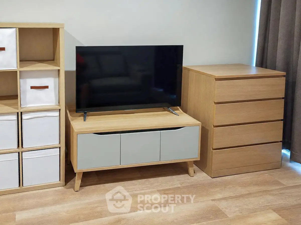 Modern living room with stylish wooden furniture and flat-screen TV, perfect for cozy relaxation.