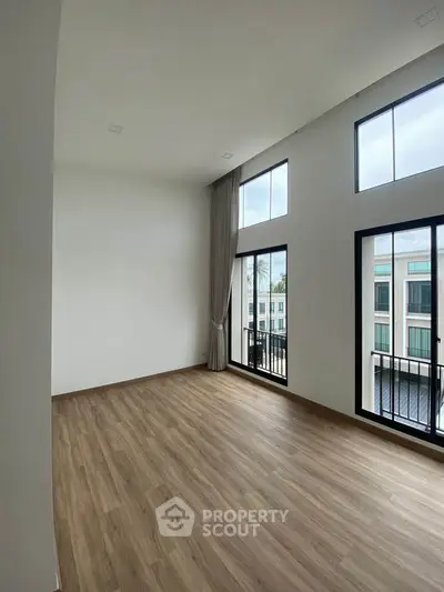 Spacious modern living room with high ceilings and large windows offering abundant natural light.