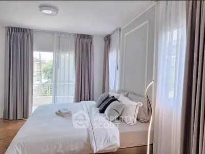 Bright and airy bedroom with modern decor and large windows for natural light.