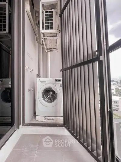 Compact balcony with washing machine and city view, ideal for urban living convenience.