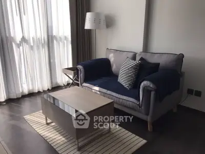 Stylish living room with cozy sofa and modern coffee table by large window.