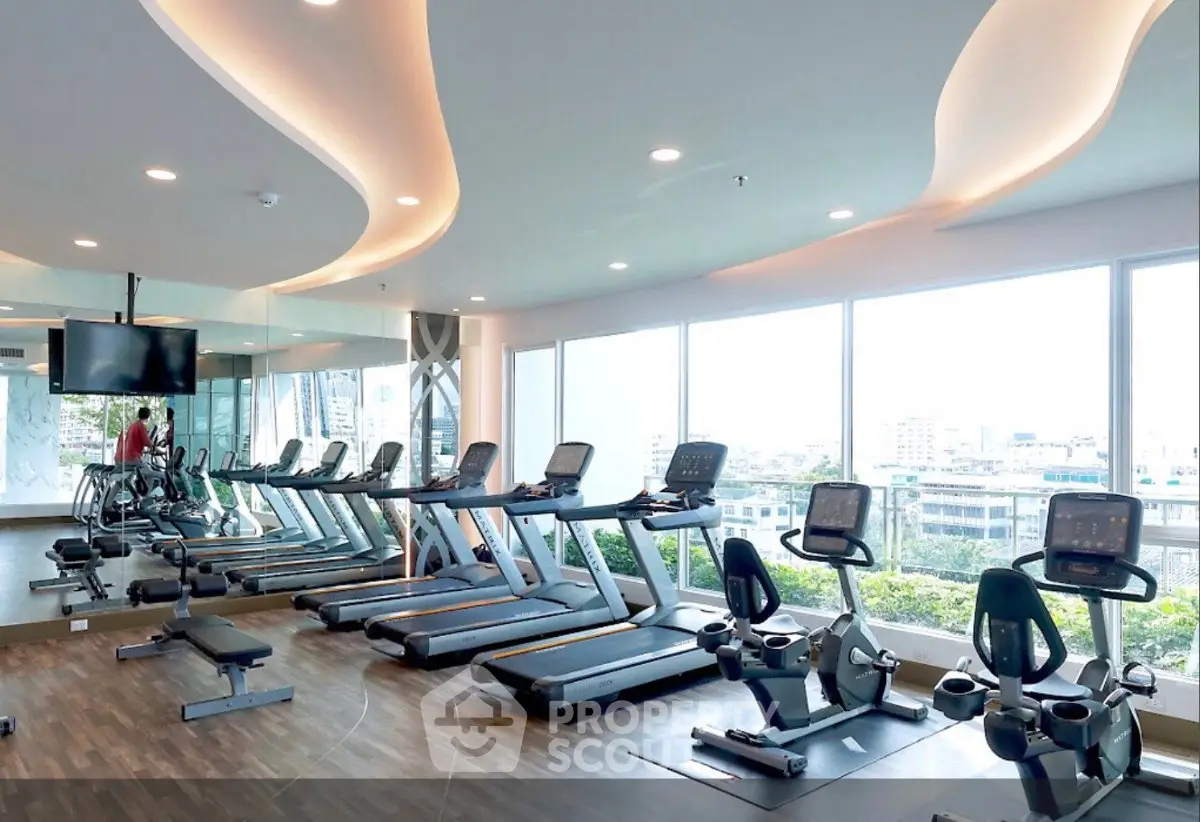 Modern gym with panoramic city views and state-of-the-art fitness equipment.