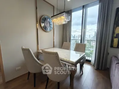 Elegant dining area with city view, featuring a chic chandelier and stylish seating.