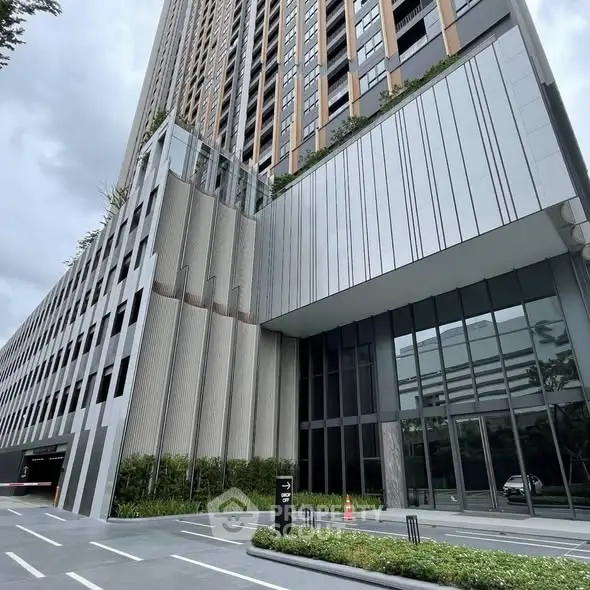 Modern high-rise building with sleek architectural design and lush greenery