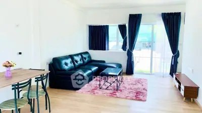 Bright living room with black leather sofa and pink rug, modern decor