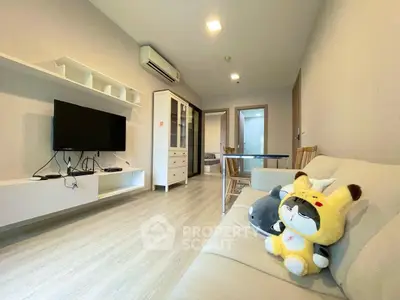Modern living room with sleek furniture and plush toys on sofa, featuring a wall-mounted TV and air conditioning.