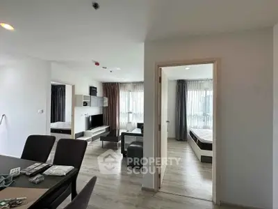 Modern apartment interior with open living room and bedroom view, stylish furniture and natural light.