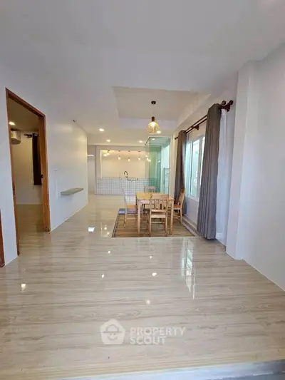 Spacious open-plan dining area with modern kitchen and large windows for natural light.