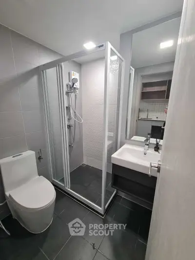 Modern bathroom with sleek shower and contemporary fixtures in stylish apartment.