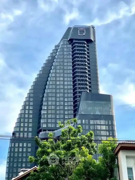 Stunning modern high-rise building with sleek architectural design and lush greenery in the foreground.