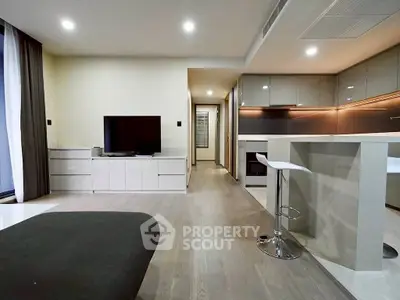 Modern open-plan living room and kitchen with sleek design and neutral tones.