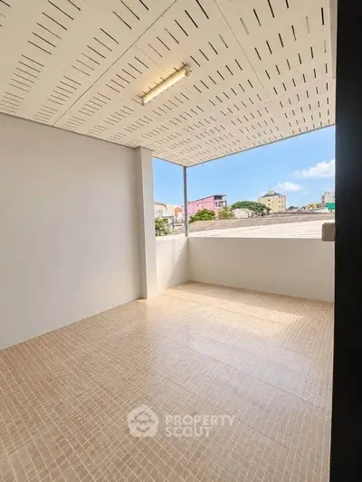 Spacious balcony with tiled flooring and city view, perfect for relaxation.