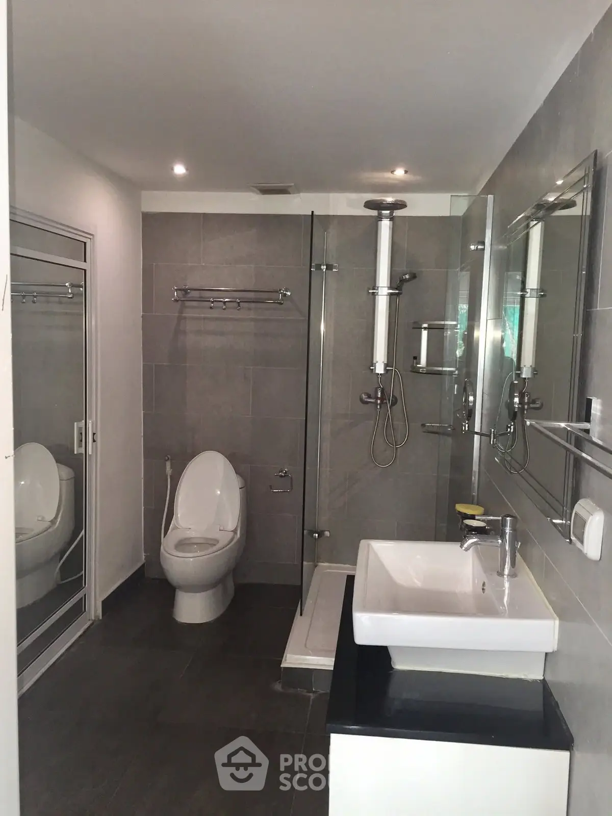 Modern bathroom with sleek fixtures and glass shower enclosure in a contemporary apartment.