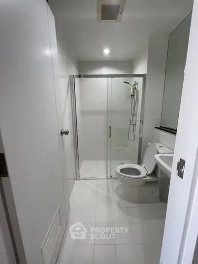 Modern bathroom with glass shower and sleek white fixtures