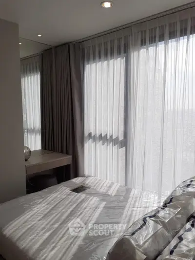 Modern bedroom with large windows and elegant curtains
