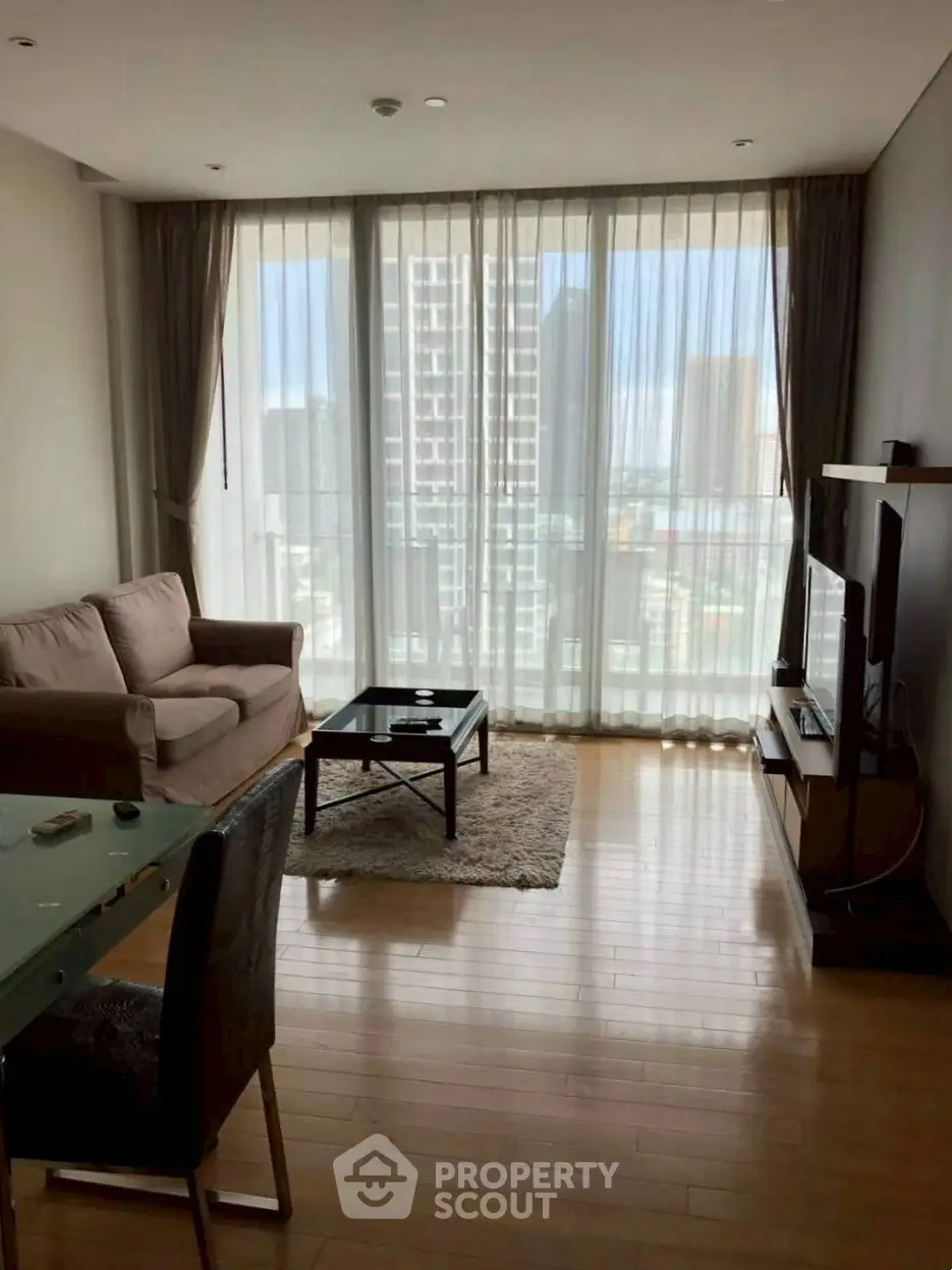 Spacious living room with floor-to-ceiling windows and city view