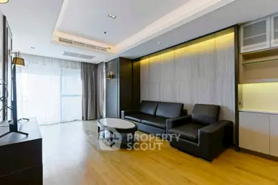 Spacious modern living room with sleek black furniture and large windows