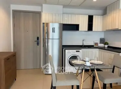 Modern kitchen with sleek appliances and dining area in stylish apartment.