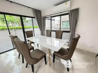 Elegant dining area with modern glass table and stylish chairs in a bright, airy room.