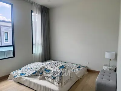 Spacious bedroom with natural light and modern decor in a contemporary home.