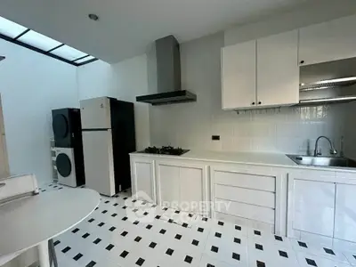 Modern kitchen with sleek white cabinetry, gas stove, and ample natural light.
