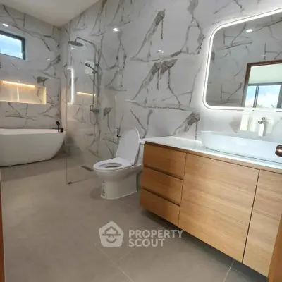 Luxurious bathroom with marble walls, modern fixtures, and elegant bathtub.