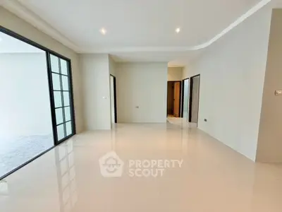 Spacious modern living room with sleek tile flooring and large windows for natural light.