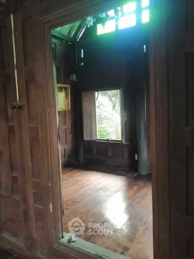 Charming rustic wooden interior with natural light and lush greenery view, perfect for serene living.