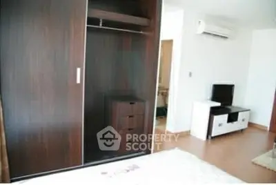 Spacious bedroom with built-in wardrobe and modern entertainment setup.