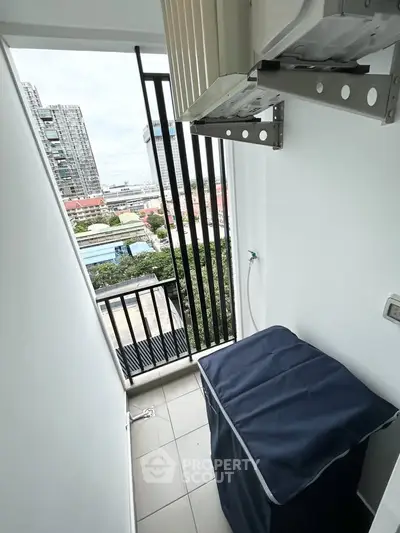 Compact balcony with city view, ideal for laundry or storage, featuring modern railing and air conditioning unit.