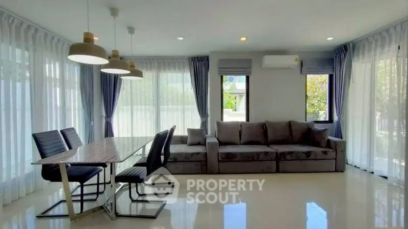 Spacious modern living room with elegant dining area and large windows