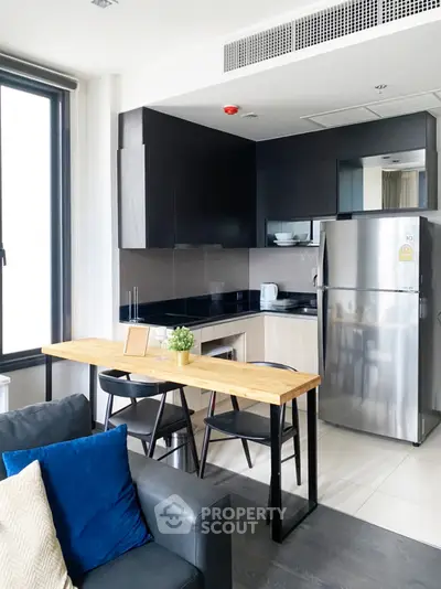 Modern kitchen with sleek cabinetry and stainless steel appliances in a stylish apartment.