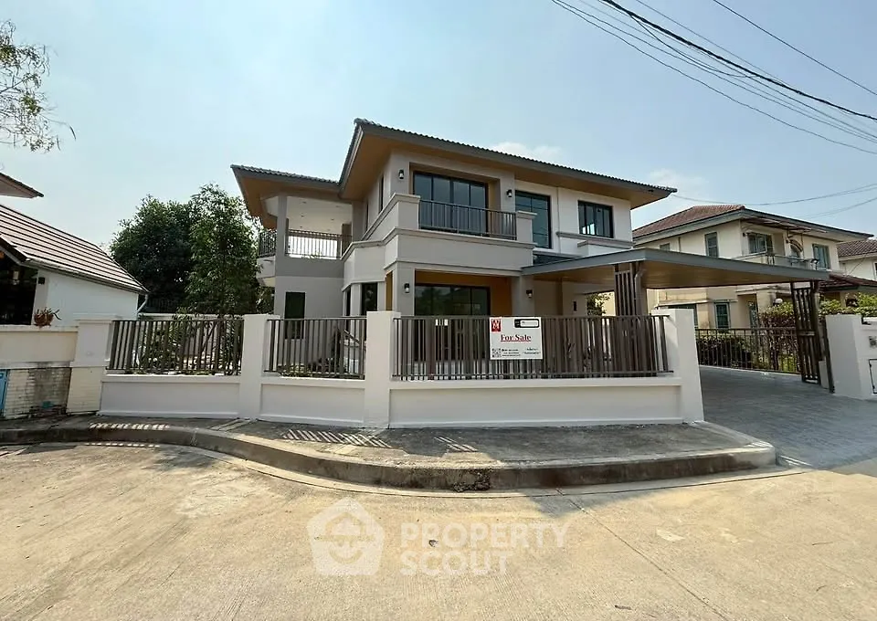Modern two-story house with spacious driveway and sleek fence design.