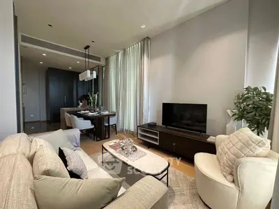 Modern living room with elegant decor and open dining area, featuring cozy seating and stylish furniture.