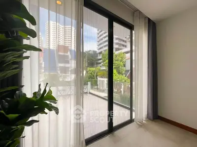 Spacious balcony with sliding glass doors and city view, perfect for relaxation.