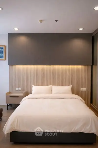 Modern bedroom with cozy lighting and elegant decor, perfect for relaxation and comfort.