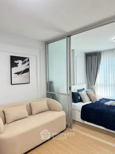 Modern bedroom with sliding glass doors and cozy sofa, featuring elegant decor and natural light.