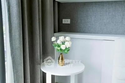 Elegant interior with white table and vase of roses, perfect for modern living spaces.
