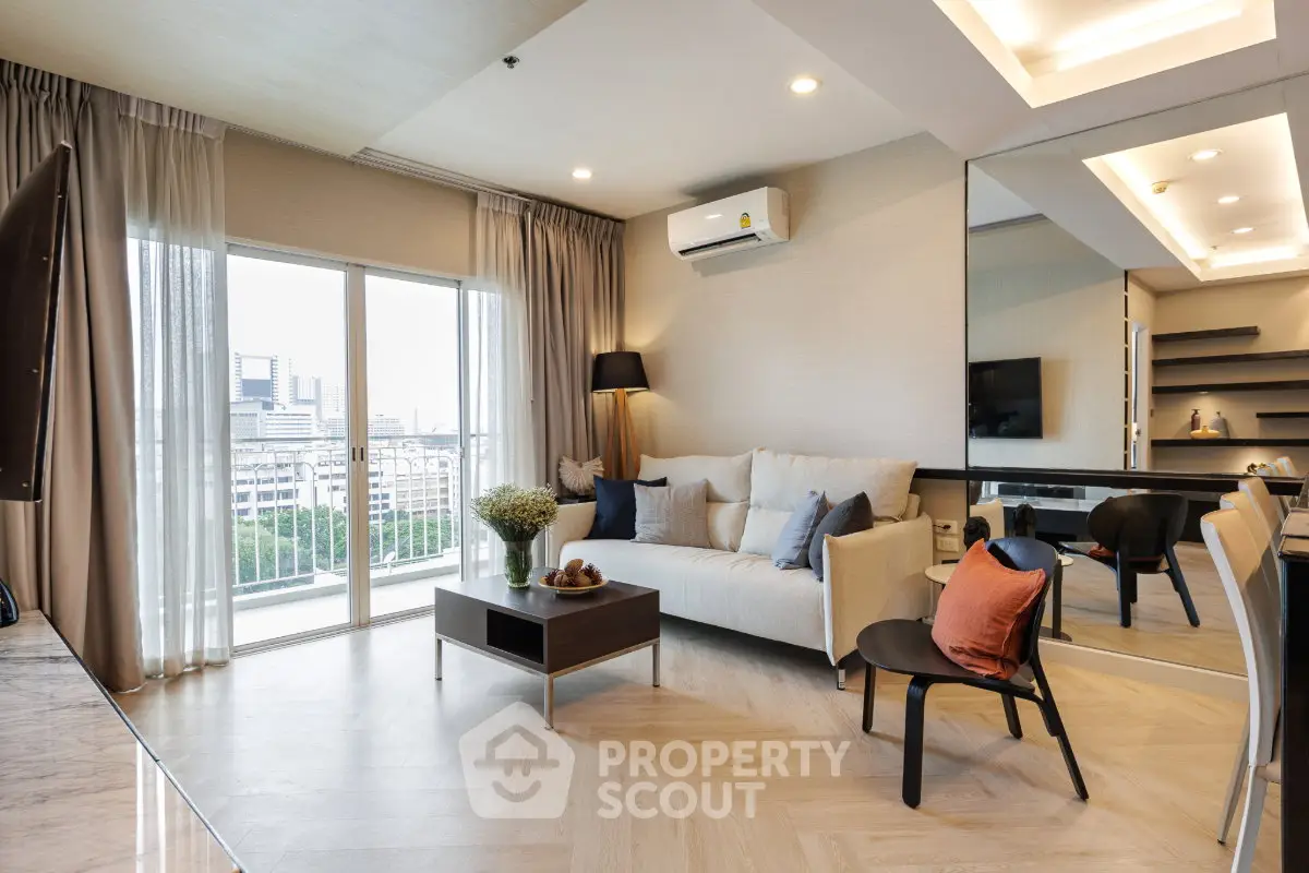Modern living room with large window and city view, featuring stylish furniture and elegant decor.